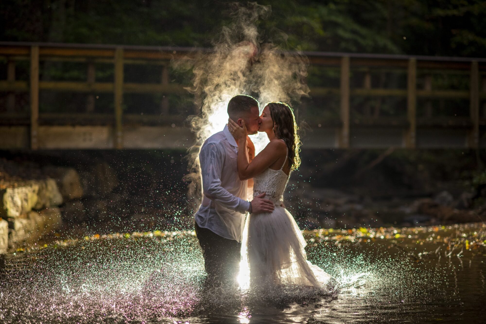 An intimate steamy kiss with an engaged couple in a pool of water. Steam rising from their bodies. Family and wedding photography in Pittsburgh.